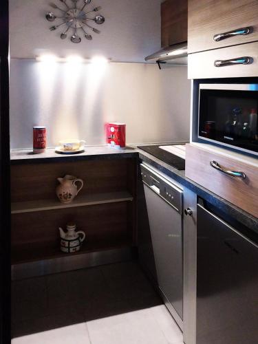 une cuisine avec une cuisinière et un micro-ondes dans l'établissement Résidence Le Belvedere - Coquet studio équipé pour 4 personnes en résidence de standing MAE-6014, aux Orres