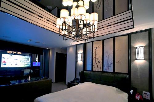a bedroom with a bed and a chandelier at Design Hotel W Zip Club in Nagoya