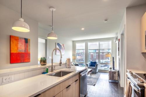 a kitchen with a sink and a living room at New Luxury Apt Downtown with Pool in Stamford