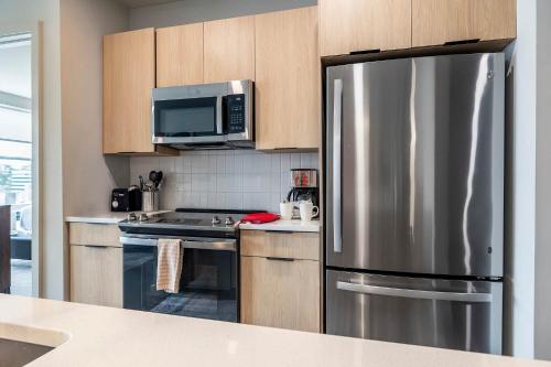 a kitchen with a stainless steel refrigerator and a microwave at New Luxury Apt Downtown with Pool in Stamford