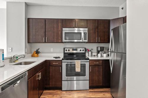 a kitchen with stainless steel appliances and wooden cabinets at Modern Apt Near Downtown in White Plains