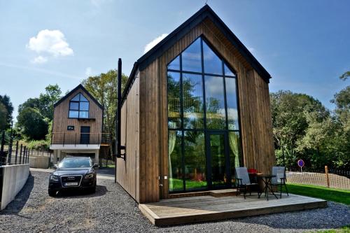 a small wooden house with a car parked in front of it at Bobrí potôčik in Liptovský Mikuláš