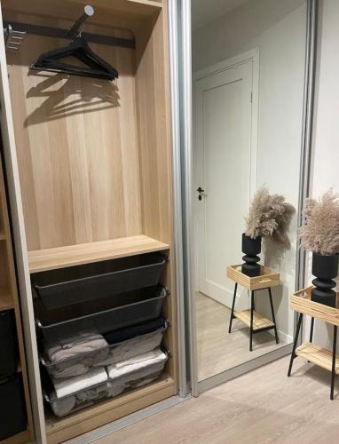 a closet with a mirror and a pile of towels at Plaza Havstad in Trondheim