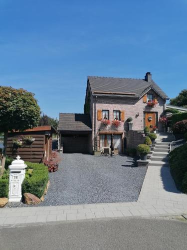 a house with a gravel driveway in front of it at Au Coin Fleuri in Malmedy