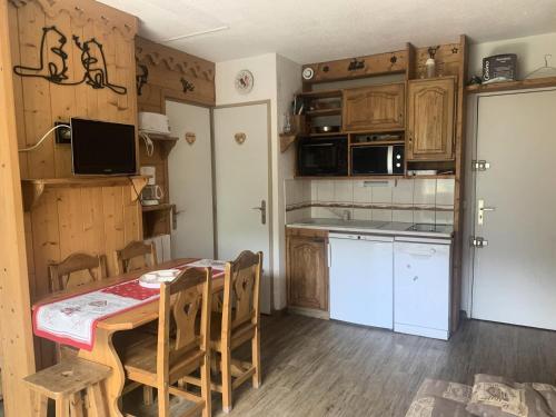 - une cuisine avec une table, une table et des chaises dans l'établissement Résidence Jetay - Appartement chaleureux pour 4 aux Ménuires MAE-5644, aux Menuires