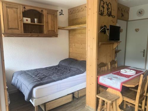 une petite chambre avec un lit et une table dans l'établissement Résidence Jetay - Appartement chaleureux pour 4 aux Ménuires MAE-5644, aux Menuires