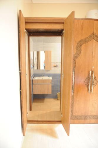 a bathroom with a wooden door and a sink at Entire home in Salé close to Rabat, Marina, beach in Sale