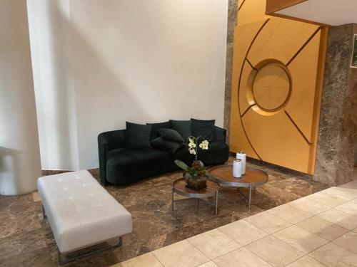 a living room with a black couch and a table at Sofisticação na Savassi in Belo Horizonte