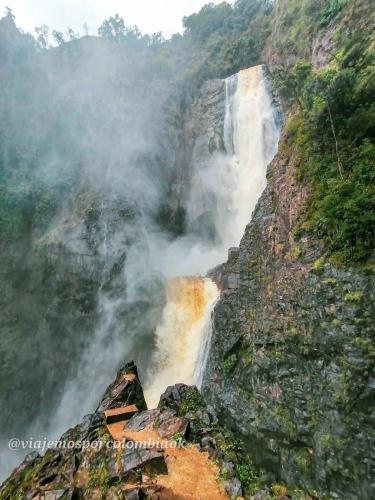 a waterfall on the side of a mountain at Hotel Cabañas y Glamping Colinas De San Diego in San Agustín
