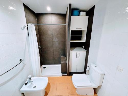 a small bathroom with a toilet and a sink at Wonderful Ocean View in Playa del Cura