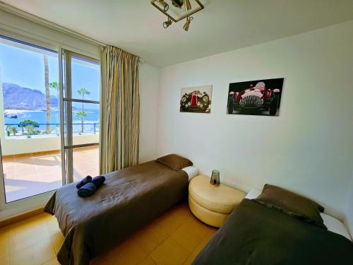 a bedroom with two beds and a large window at Wonderful Ocean View in Playa del Cura
