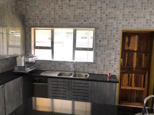 a kitchen with a sink and a window at Pomona BB House in Harare
