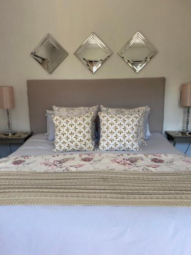a bedroom with a bed with two mirrors on the wall at Lielies Guesthouse in Parys