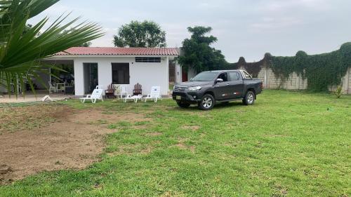 a black truck parked in front of a house at Fundo GHANDY ALLIZON in Larrea