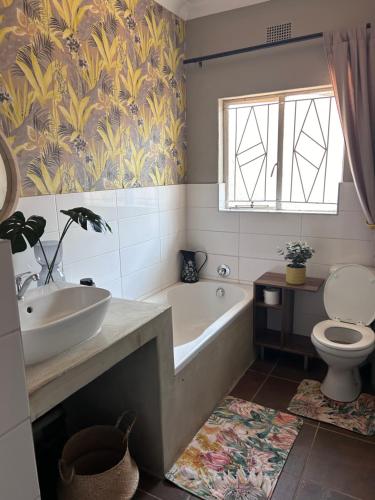 a bathroom with a tub and a sink and a toilet at Lielies Guesthouse in Parys