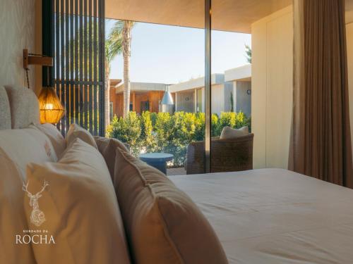 a bedroom with a bed and a large window at Herdade da Rocha - Boutique Lodge in Crato