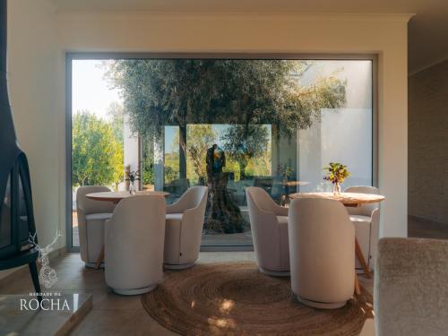 a dining room with tables and chairs and a large window at Herdade da Rocha - Boutique Lodge in Crato