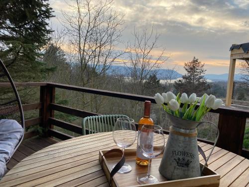a table with wine glasses and a vase of flowers at Zebikuckó vendégház in Zebegény