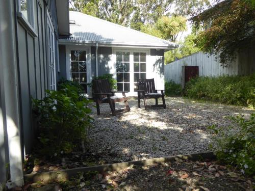 two chairs sitting on the porch of a house at Waipapa - The Heart of the Harbour in Diamond Harbour