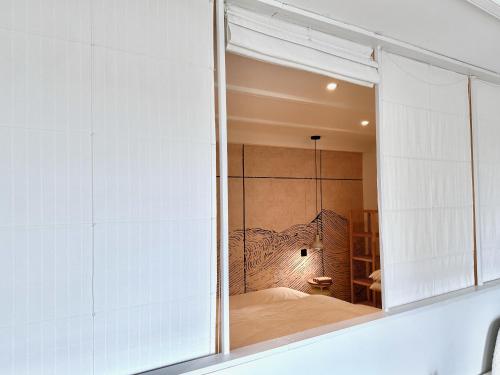 a bedroom with a window with a bed in it at Au Bon Accueil - Appartement vue mer - Hyper centre - Avec Home-Cinéma in Carantec