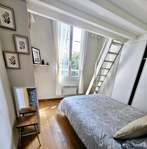 - une chambre avec un lit et un escalier avec une fenêtre dans l'établissement Basilique Métro 13, à Saint-Denis