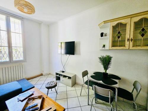 Una sala de estar con una mesa y un comedor. en Basilique Métro 13, en Saint-Denis