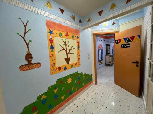 a hallway with paintings on the walls of a room at Nubian Village by the Sea in Alexandria
