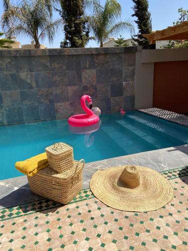 a swimming pool with a pink swan in the water at VILLA De LUXE in Marrakesh