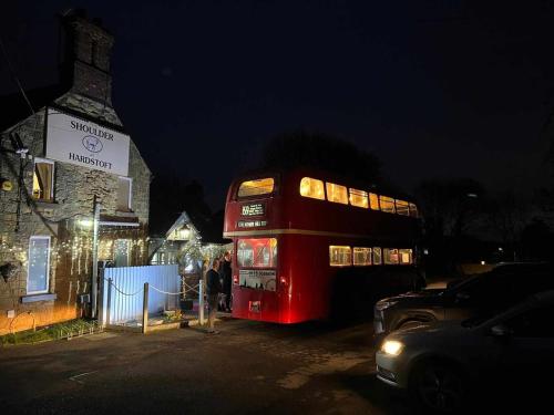 a red double decker bus parked next to a building at The Shoulder at Hardstoft in Hardstoft