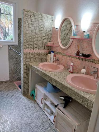 une salle de bain avec deux lavabos et deux miroirs dans l'établissement Ly Jymjac Saint Hilaire de Riez St Jean de Monts, à Saint-Hilaire-de-Riez