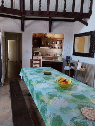 une cuisine avec une table avec un bol de fruits dessus dans l'établissement Ly Jymjac Saint Hilaire de Riez St Jean de Monts, à Saint-Hilaire-de-Riez