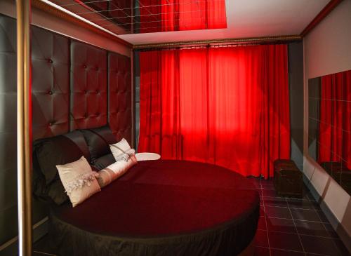 a red room with a bed and a red curtain at Villa Kika Traviesa in La Bañeza