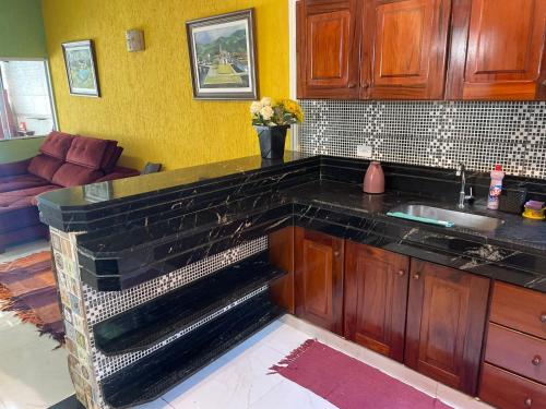 a kitchen with a black counter top in a room at Duplex com piscina in Paraty