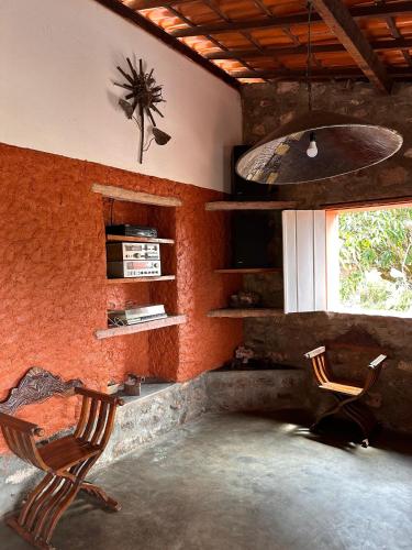a room with two chairs and a desk and a window at Recanto Bela Vista Igatu in Igatu