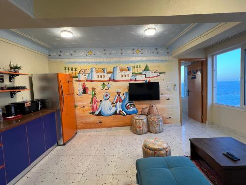 a kitchen with a painting on the wall at Nubian Village by the Sea in Alexandria