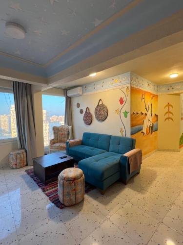 a living room with a blue couch and a table at Nubian Village by the Sea in Alexandria