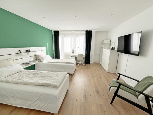 a hotel room with two beds and a television at Goldstadt Apartments in Pforzheim