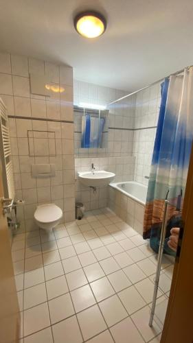a bathroom with a toilet and a tub and a sink at Arkonablick 53 in Juliusruh