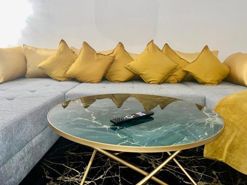 a couch with yellow pillows and a remote control on a table at Weißes Haus in Gerasdorf bei Wien