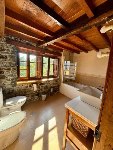 a bathroom with two toilets and a sink and a tub at La Fontina de Tene in Tene