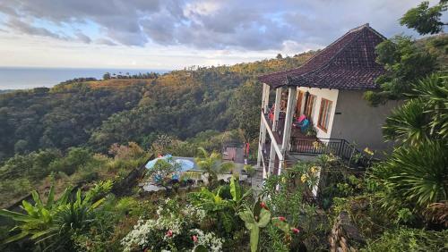 a house on the side of a hill with trees at Liri Villa - 4 BRs - Ocean, Valley view in Temukus
