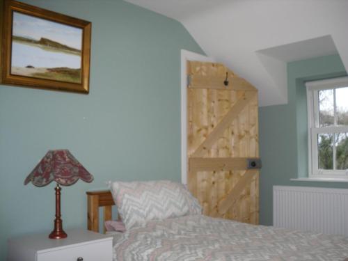 um quarto com uma cama e uma porta de madeira em The Homecoming Barn em Clogher