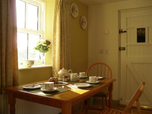 una mesa con tazas y platillos en una habitación en The Homecoming Barn en Clogher