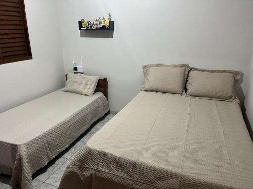 Ένα ή περισσότερα κρεβάτια σε δωμάτιο στο Casa de Temporada Ipê Rosa