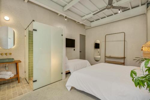 a bedroom with two beds and a mirror at Botánica Casa Hotel Manila by HOUSY HOST in Medellín