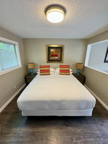 a bedroom with a large white bed with red and yellow pillows at Hidden Valley Inn in Carmel Valley