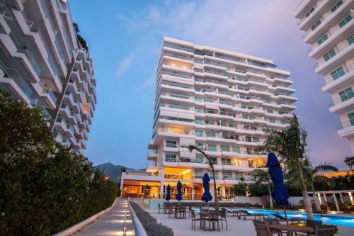 ein großes weißes Gebäude mit Tischen und Stühlen davor in der Unterkunft Espectacular Apartamento 211 M2, Playa Dormida Dos in Playa Dormida