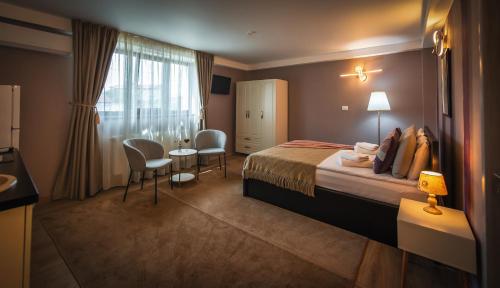 a hotel room with a bed and a table and chairs at AMADA CITY CENTER in Iaşi