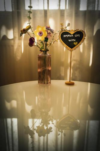 a vase with flowers on a table next to a sign at AMADA CITY CENTER in Iaşi