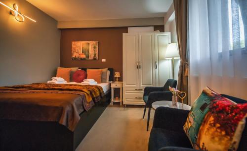 a hotel room with two beds and a chair at AMADA CITY CENTER in Iaşi